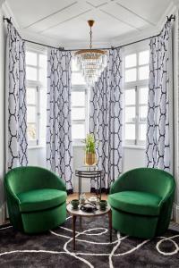 a living room with two green chairs and a table at Cape Cadogan Boutique Hotel in Cape Town
