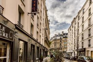 a city street with buildings and cars on the street at District Republique in Paris