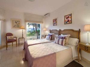 a bedroom with a large bed and a window at VILLA LANTANA Lujo y estilo con vistas únicas al puerto de Mahón in Cala Llonga