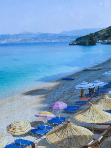 a beach with many umbrellas and the ocean at Villas Ermali in Ksamil