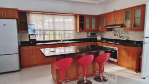 a kitchen with wooden cabinets and red bar stools at Bretthouse Tourist Inn in Lila