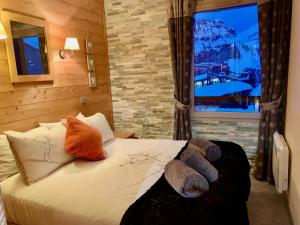 a bedroom with a bed with pillows and a window at Luxury Chalet with sauna by Avoriaz Chalets in Avoriaz