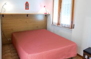a red bed in a room with a window at M033 - Marcelli, trilocale in centro fronte mare in Marcelli