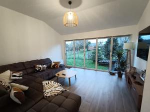 salon z kanapą i stołem w obiekcie Grande, belle maison de ville idéale 24 h du Mans w mieście Vaas