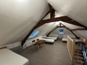 pokój na poddaszu z dwoma łóżkami i stołem w obiekcie Grande, belle maison de ville idéale 24 h du Mans w mieście Vaas