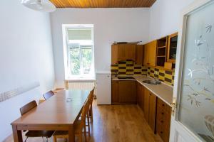 a kitchen with a wooden table and a dining room at Prenočišče Maribor Center in Maribor