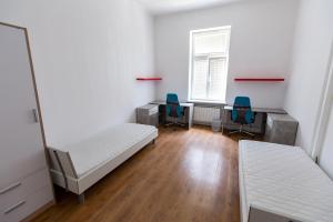 Zimmer mit 2 Betten, 2 Schreibtischen und 2 Stühlen in der Unterkunft Prenočišče Maribor Center in Maribor
