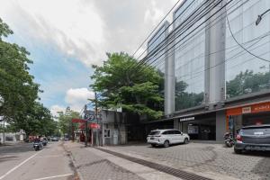 a white car parked in front of a building at RedDoorz @ Pelajar Pejuang 3 in Bandung