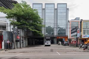 a city street with cars parked in front of a building at RedDoorz @ Pelajar Pejuang 3 in Bandung