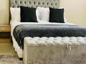 a bedroom with a large bed with a large headboard at Commodious and Contemporary double home - 2042 in Bulawayo