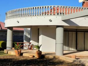 a white house with a staircase on top of it at Commodious and Contemporary double home - 2042 in Bulawayo