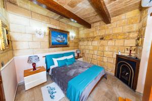 een slaapkamer met een bed in een kamer met een open haard bij Valletta Traditional Townhouse in Valletta