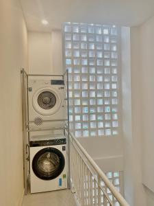 - un lave-linge et un sèche-linge dans un couloir avec un escalier dans l'établissement Mưa home, à Đà Nẵng