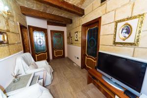 a living room with a flat screen tv and a couch at Valletta Traditional Townhouse in Valletta