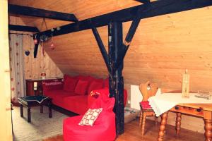 uma sala de estar com um sofá vermelho e uma mesa em Droneberger-Hütte 