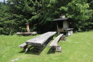 un banc en bois dans un champ avec une maison pour oiseaux dans l'établissement Droneberger-Hütte, 