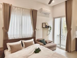 a bedroom with a bed and a window and a couch at Mưa home in Da Nang