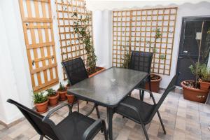 雅典的住宿－Beautiful new apartment in Petralona，庭院里种有盆栽植物,摆放着黑色的桌子和椅子