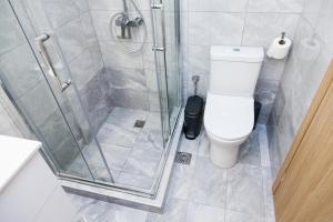 a bathroom with a toilet and a glass shower at Beautiful new apartment in Petralona in Athens