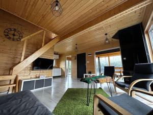 a living room with wooden walls and a wooden ceiling at Dom Małe Mazury in Drozdowo