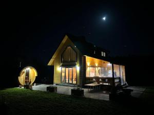 Una casa di notte con la luna nel cielo di Dom Małe Mazury 