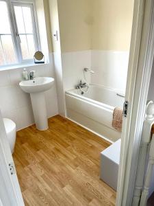 uma casa de banho com um lavatório, uma banheira e um WC. em Stunning Large Detached Gloucester, 4 beds, 3 bedroom, 2 bathroom property, Nr Chelt, The Docks and Quays sleeps 6 em Gloucester