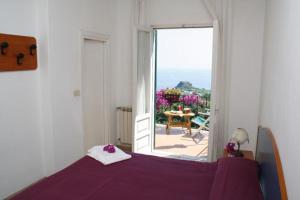 a bedroom with a purple bed and a large window at Hotel Bellavista Ischia in Ischia