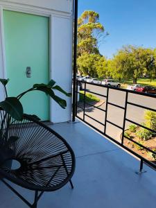 a chair on a balcony with a view of a parking lot at Ringtails Motel in Busselton