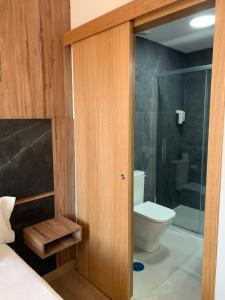 a bathroom with a toilet and a glass shower door at Pensión Da Estrela in Santiago de Compostela