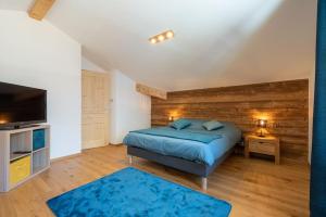 a bedroom with a bed and a flat screen tv at Les 3 Sophies - Magnifique chalet pour 1 à 8 personnes proche des remontées mécaniques des prodains in Morzine