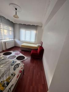 ein Schlafzimmer mit einem Bett und einem roten Stuhl in der Unterkunft Şehir Manzaralı Büyük Bahçeli Villa 