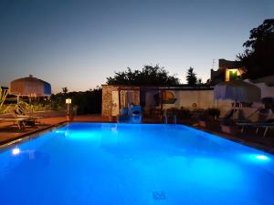 a large blue swimming pool at night at Hotel Bellavista Ischia in Ischia