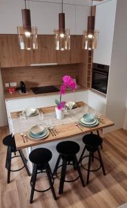 une cuisine avec une table en bois et 4 chaises dans l'établissement Apartman Orhideja, à Fužine