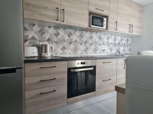 kuchnia z drewnianymi szafkami i kuchenką w obiekcie Fabulous Villa Mabel w Corralejo