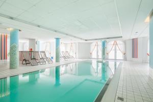 una piscina con sillas y agua en un edificio en Villa Hanse Wohnung 319 en Kühlungsborn