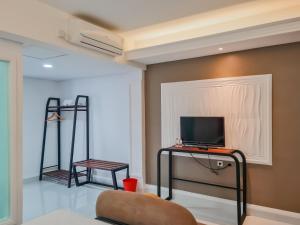 卡拉旺的住宿－Sans Hotel Grand Sabaraya Cikampek，客厅配有桌椅和电视机