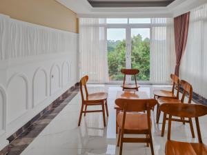 Zimmer mit Stühlen, einem Tisch und einem Fenster in der Unterkunft Sans Hotel Grand Sabaraya Cikampek in Karawang