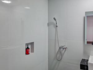 卡拉旺的住宿－Sans Hotel Grand Sabaraya Cikampek，白色的浴室设有淋浴和灭火器