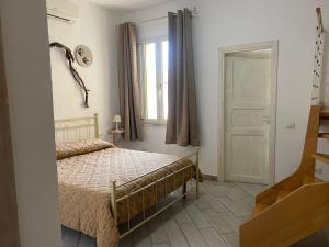 a bedroom with a bed and a window and a door at Casa Ilva in La Maddalena