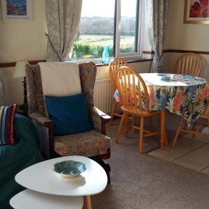 a living room with a table and a chair and a table sidx sidx at Armada Lodge Seashore Holiday Apartment in Grange