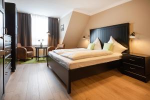 een slaapkamer met een groot bed met een zwart hoofdeinde bij City Hotel in Geilenkirchen