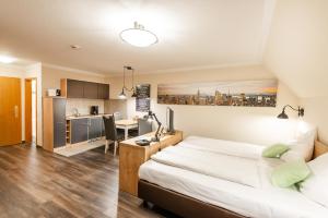 a bedroom with a large bed and a kitchen at City Hotel in Geilenkirchen