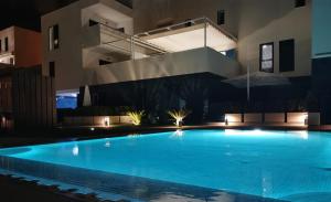 a large swimming pool in front of a building at night at Turquesa del Mar - Max Beach Golf - Large Sunny Terrace Apartment in Playa Flamenca