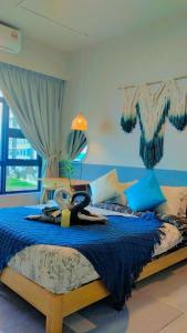 a bedroom with a large bed with blue pillows at MLH Designer Suites @ Jesselton Quay CityPads in Kota Kinabalu