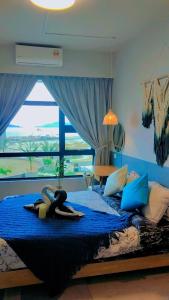 Eine Frau, die in einem Schlafzimmer auf einem Bett liegt. in der Unterkunft MLH Designer Suites @ Jesselton Quay CityPads in Kota Kinabalu