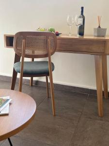 a chair sitting at a wooden table with wine glasses at Acropolis View Apartment Athens Downtown in Athens