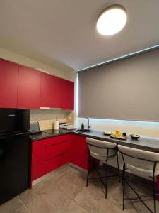 una cucina con armadi rossi e frigorifero nero di Acropolis View Apartment Athens Downtown ad Atene