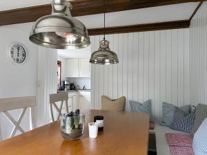 - une cuisine avec une table et deux lumières dans l'établissement Reetkate Reetdachhaus Friesen Chalet, à Tating 19 autres photos
