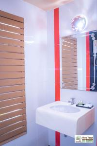 La salle de bains est pourvue d'un lavabo blanc et d'un miroir. dans l'établissement Ingtarn Ressort At thasala, à Ban Nai Thung