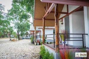 a house with wooden accents and a walkway outside at Ingtarn Ressort At thasala อิงธารรีสอร์ท ท่าศาลา in Ban Nai Thung